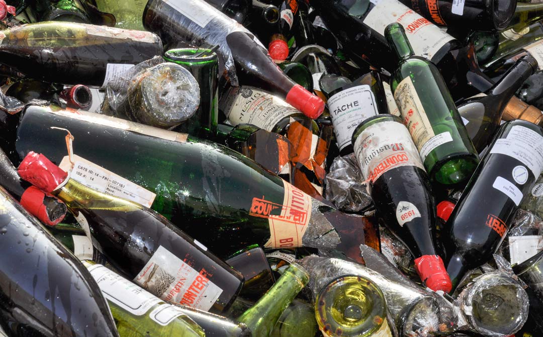 Pile of broken wine bottles and counterfeit labels after seizure or destruction